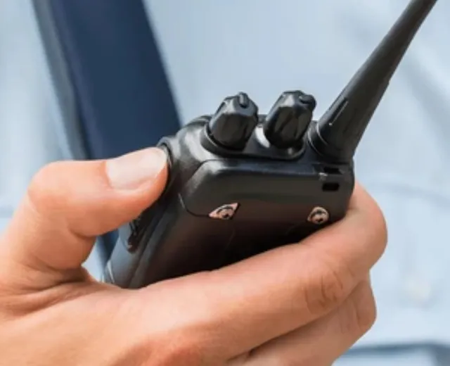 Walkie-talkie en la mano de un miembro de la organización